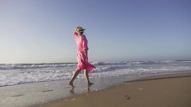 Silhuett kvinna i flyger i vind rosa klänning vid solnedgången höja huvudet upp i luften — Stockvideo
