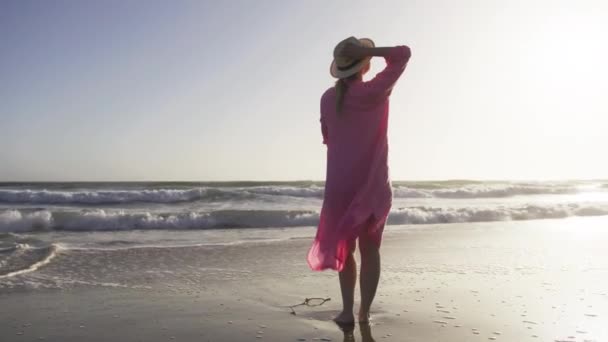 Jong fit amerikaanse vrouw glimlachen, omarmen zichzelf op filmische zandstrand rood — Stockvideo