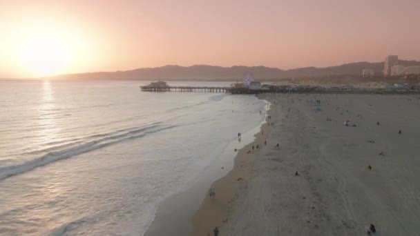 Crepúsculo olas del océano, rueda del hurón clásico, parque de atracciones en el muelle de Santa Mónica — Vídeo de stock