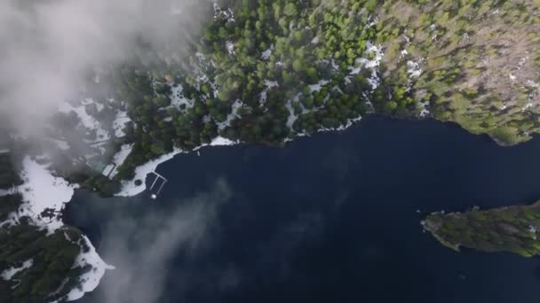 Diep blauw water in bergbos, meer met pijnbomen op winterdag 4K antenne — Stockvideo