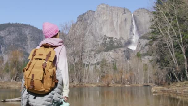 Жінка мандрівник з питною водою, що йде по гірській річці в гірському лісі — стокове відео