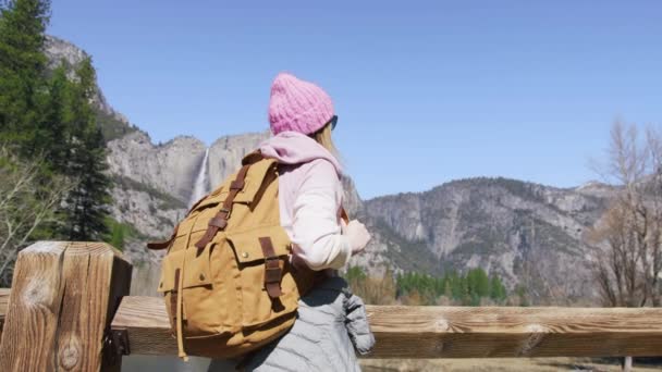 Жінка подорожує з туристичним рюкзаком на дерев "яному мосту в зеленому лісі Йосеміті. — стокове відео