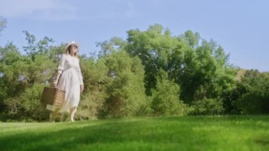 Kırmızı kamera yavaş çekim ticari görüntüler. Yeşil parkta yürüyen güzel kadın.