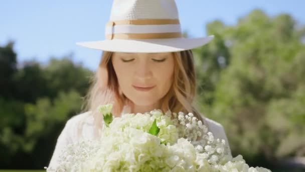 Caméra rouge au ralenti portrait belle femme sentant doux fleurs blanches 6K — Video