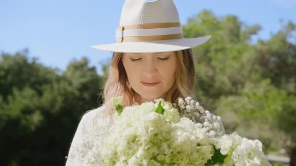 白い花の花束を嗅ぐ美しい笑顔の女性の閉鎖ポートレート赤 — ストック動画