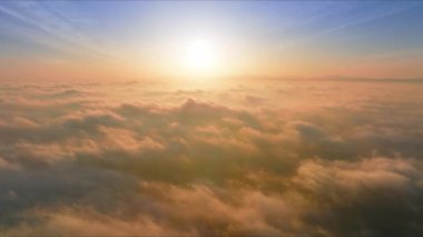 Parlak güneş ışığı parlıyor, güneş ışığı renkli kümülüs bulutlarının üzerinde parlıyor. 4K