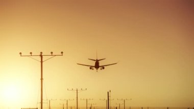 6K Airplane etkileyici iniş Altın turuncu gökyüzünde uçuyor