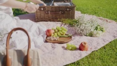 6K yazında piknik sepetinden peyniri alan kadın.