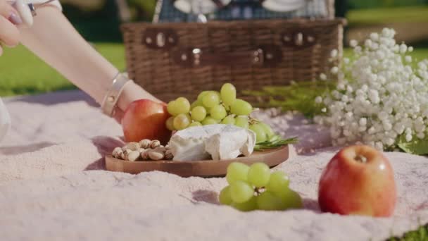 Primeros planos de la mano femenina tomando rebanada de queso molde, queso francés en el tablero de frutas — Vídeos de Stock