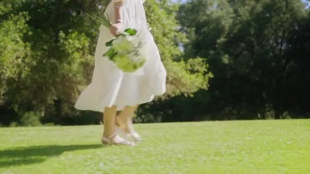 白い花を手に夏の森を歩く若い幸せな女性, 6K REDショット — ストック動画