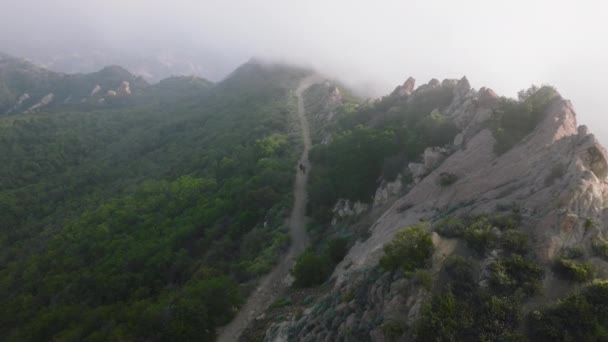 4K outdoor nature background. Fog flying above hikers walking by mountain trail — ストック動画