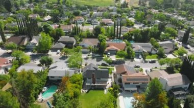 Van driving along a valley with lush greenery and high end property