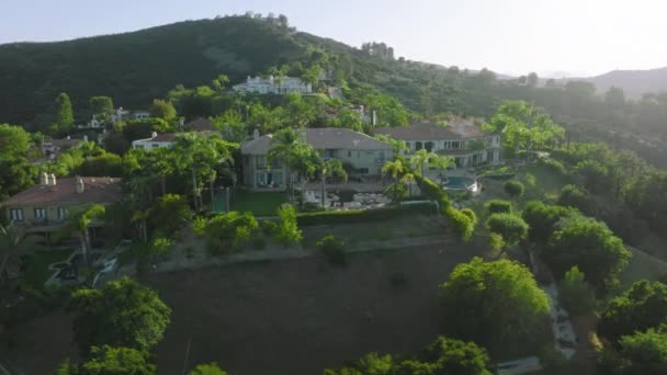 Вид с воздуха на резиденцию, скрывающуюся в пышной зелени холмистой местности — стоковое видео