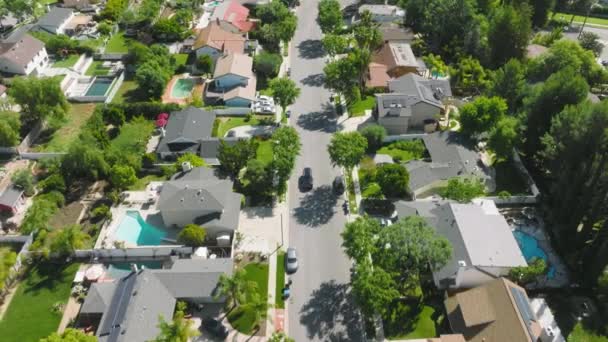 Aerial footage of a car driving along charming suburbs with beautiful villas — Stockvideo