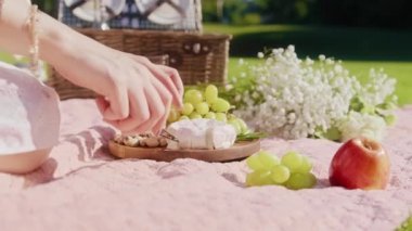 Yakından kadın eli bir dilim peynirli, aperatif peynir tabağı 6K alıyor.