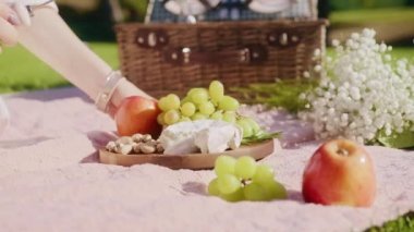 Closeup female hand taking slice of mold cheese, french cheese on fruits board