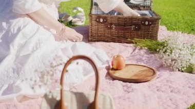 Açık piknik sepetinden meyve toplayan bir kadın. Yazın tahta tabağa koyuyor.