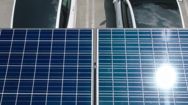 Coche eléctrico en el estacionamiento con estación de carga bajo baterías de panel solar 4K — Vídeo de stock