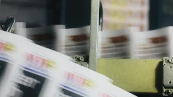 En veckotidning färgglada kopior på en pappersmatare i ett stort tryckeri — Stockvideo