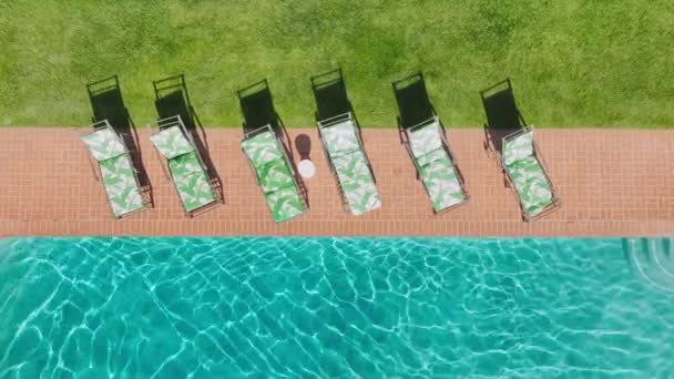 空中休暇の映像太陽の反射とティールブルーの水面で完璧なスイミングプールトップダウン リゾートプールでの旅行の休日を楽しむ日光浴をリラックスした背景 高級ライフスタイル — ストック動画