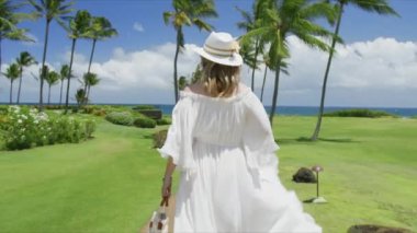 Genç ve mutlu bir kadının el kaldırmasını yavaş çekimde izleyeceğiz. Tropikal Hawaii adasında esintide uçan güzel beyaz elbiseli bir kadın. Sinema yaz arkaplanı, tatil seyahati kırmızı 6K