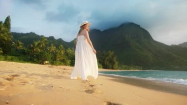 Seyahat etkeni Hawaii adasındaki ünlü bir yeri ziyaret ediyor. Hawaii 'de tatilde, cennet Kauai sahilinde tatil yapan bir kadın. Otelde lüks bir seyahatte olan kız. Beyaz elbiseli mutlu kadın, Red.