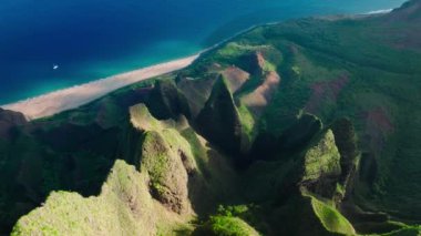 Harika derin mavi okyanus suları. Dik yeşil duvarları olan keskin yüksek yeşil tepeler. Tropikal doğanın panoramik güneş manzarası, 4K görüntü. Vahşi doğada peri gibi yeşil dağ sırtı