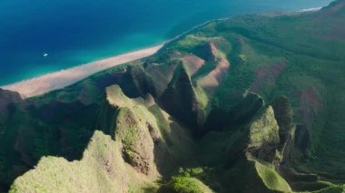 Harika derin mavi okyanus suları. Dik yeşil duvarları olan keskin yüksek yeşil tepeler. Tropikal doğanın panoramik güneş manzarası, 4K görüntü. Vahşi doğada peri gibi yeşil dağ sırtı