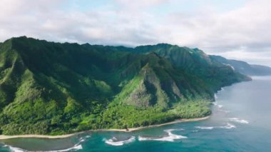 Helikopter panoramik manzaralı tropik Kauai doğası. Vahşi ada doğasının sinematik yeşil dağ manzarası. Dik yeşil duvarları olan yüksek yeşil tepelerde harika derin mavi okyanus dalgaları.