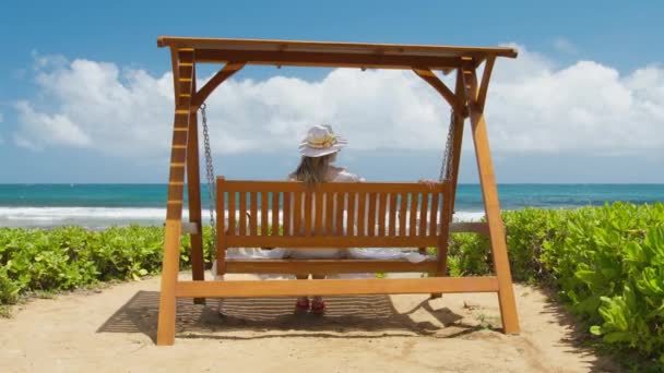夏の夢の旅に素晴らしい時間を持っている女性 女性は休日の休暇の冒険に乗ってスイング 海のビーチでリラックス 熱帯の花と帽子のロマンチックな女性 ハワイのホテルのリゾートでリラックスした女の子 — ストック動画