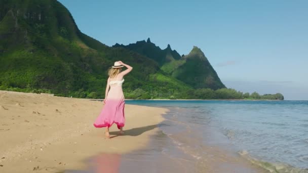 Kobieta Kolorowym Stroju Biegnie Przez Ocean Beach Malowniczymi Szczytami Gór — Wideo stockowe