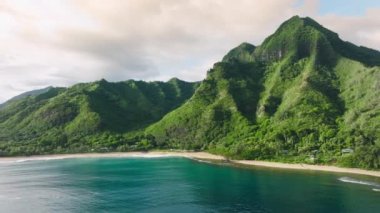 Sinematik Hawaii doğa manzarası havadan 4K. Kopya alanı olan egzotik yaz tatili geçmişi. Yüksek yeşil dağların yağmur ormanlarıyla kaplı olduğu Teal mavisi bir okyanus. Tropik ada macerası