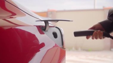 Kyiv, Ukrayna. Nisan 2021. Kırmızı Tesla EV için kullanılan hızlı şarj istasyonu. Sürücü, elektrikli aracına hızlı şarj cihazı takıyor. Yüksek kalite 4k görüntü