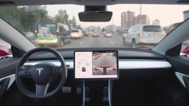 Kyiv, Ukrayna. Ağustos 2021. Otomatik direksiyon özelliğine sahip gelecekçi Tesla aracı kendi kendini sürüyor. Otomatik pilot tam otomatik pilotla yolda gidiyor. Yüksek kalite 4k görüntü