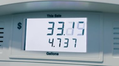 Benzin pompası benzin istasyonunun benzin fiyatları galon başına 7 doların üzerine çıkarken benzin, Kaliforniya, Amerika 'da 7 galon benzin için 50 dolara çıkarılıyor. Kırmızı kamera doli görüntüsü