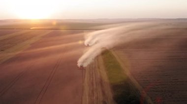 Sarımsı buğday çiftliğinin havadan görünüşü. Büyük tarım çiftliği içinde çalışan hasat makineleri. Yüksek kalite 4k görüntü