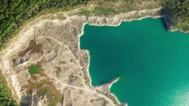 Yapay yeşilimsi gölün eşsiz büyüleyici manzarasının havadan görünüşü. Dürzhba taş ocağı tepelerde kumlu kıyılar ve sık ormanlarla dolu. Yüksek kalite 4k görüntü
