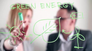 Modern bir ofiste cam bir tahtaya grafik çizen bir kadın. İnsanlar yenilenebilir kaynaklar hakkında bir sunum hakkında tartışıyorlar. Yüksek kalite 4k görüntü