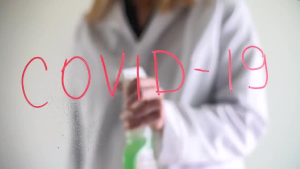 隔離期間中の成人女性屋内 医師はコロナウイルスのシンボルを消去するために液体を噴霧します 高品質4K映像 — ストック動画