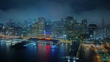 San Francisco 'da gece aşırı hız. Aydınlatılmış Business Financial Downtown City ve Skyscrapers Tower binaları San Francisco Körfezi sularında zaman aşımına neden oldu. Güzel hava şehri gece ışıkları 4K