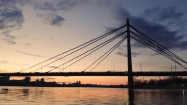 Kyiv, Ukrayna. Yoğun trafiği ve arka planda günbatımının olduğu canlı büyük bir şehrin havadan görünüşü. Nehir boyunca güzel köprüsü olan panoramik manzara. Yüksek kalite 4k görüntü