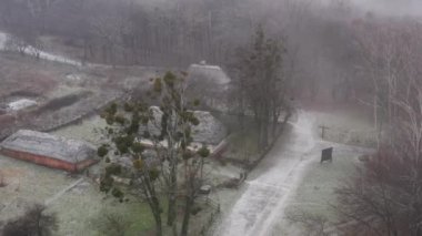Kyiv, Ukrayna. Aralık 2020. Folk Müzesi 'nin ahşap evlerle çekilmiş hava görüntüleri. Saman çatılı tipik bir ev, yukarıdan manzara. Yüksek kalite 4k görüntü