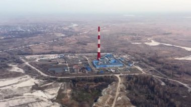 Kyiv, Ukrayna. Fabrika borusu tarlanın içinde ve şehir manzarası da arka planda. Şehrin kenar mahallelerinde endüstriyel tesislerin insansız hava aracı görüntüleri. Yüksek kalite 4k görüntü