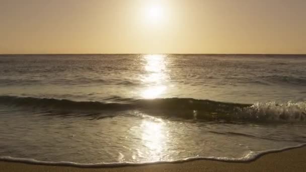 灿烂的燃烧的天空映衬着金光闪闪的背景 金黄的落日在岛上的海滩上 慢镜头闪烁着波涛 在低发亮的阳光下滚向沙滩 戏剧化的海上日出 — 图库视频影像