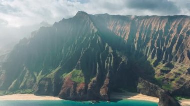 Sinematik Hawaii doğa manzaraları. Güzel volkanik dağ sırtları olan NaPali sahili. Vahşi mavi okyanus sahilindeki yeşil ve kırmızı garip şekilli tepelerin inanılmaz manzarası. Açık hava macerası