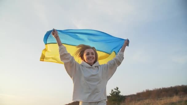 Een Jonge Blonde Vrouw Zwaait Met Oekraïense Vlag Bij Zonsondergang — Stockvideo