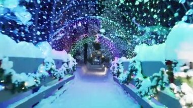 Slow motion text space with colorful magical Christmas footage background, 6K shot on RED camera. Cinematic winter wonderland park illuminated at night. Arch bridge tunnel, Christmas trees under snow