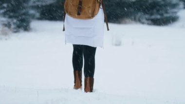 Yavaş hareket eden kadın ayakları, kar yağışlı kış gününde taze beyaz kar altında kış botlarıyla yürürken ayak izleri bırakıyor. Aspen Colorado ABD 'de kış tatilindeki kadın turist. Sırt çantalı bir kadın.