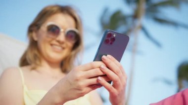 Adult female entrepreneur connected wireless network on her summer holiday outdoors. Caucasian woman in her 30s within tropical summer environment. High quality 4k footage