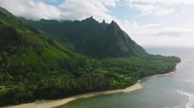 Yeşillik ve durgun deniz ile çene kıran doğal manzaranın hava görüntüleri. Tropikal yağmur ormanları, berrak ufuk çizgisinin altında köpüklü dalgalarla turkuaz açık sulara yansıyor. Yüksek kalite 4k görüntü